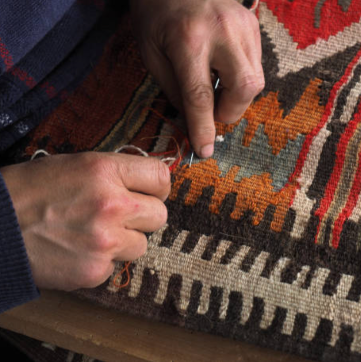 Artisan repairing a rug