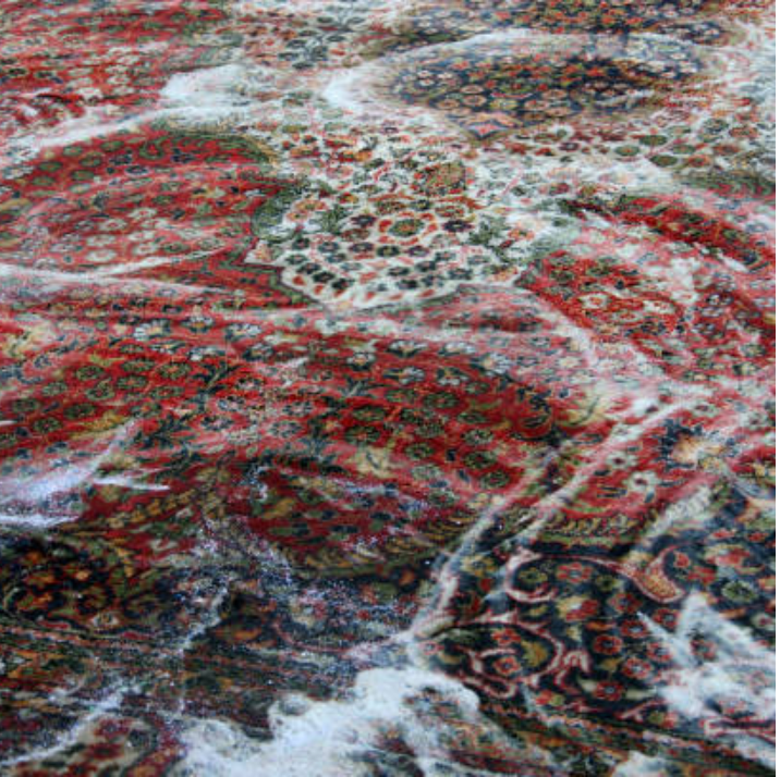 A red rug being cleaned with soap 