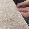 An Artisan at Carpet Culture in NYC binding a rug